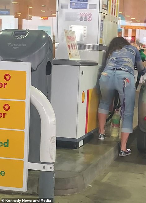 48450241-10032063-A_woman_fills_empty_plastic_water_bottles_with_fuel_on_the_M25_a-a-27_163274839380