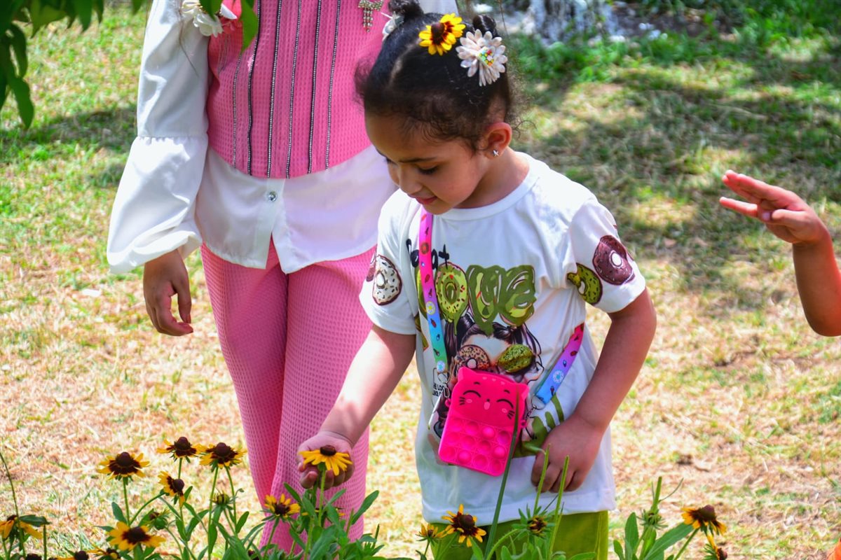 طفلة تزيين شعرها بالورود داخل حديقة الأزهر