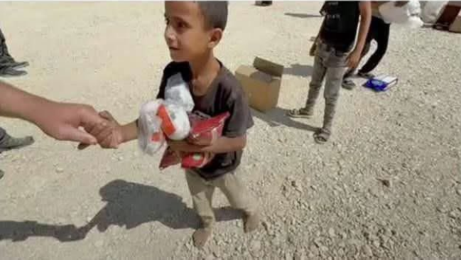 أمير يمسك بيد ضابط الجيش الأمريكي في موقع المساعدات، فيتو