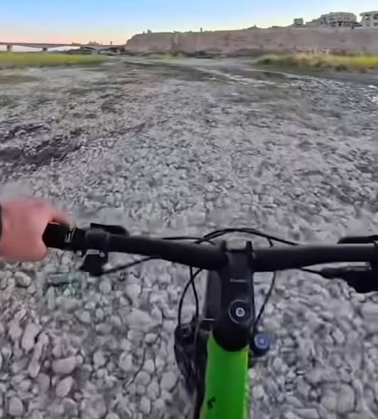شاب يسير في نهر دجلة بدراجته، فيتو