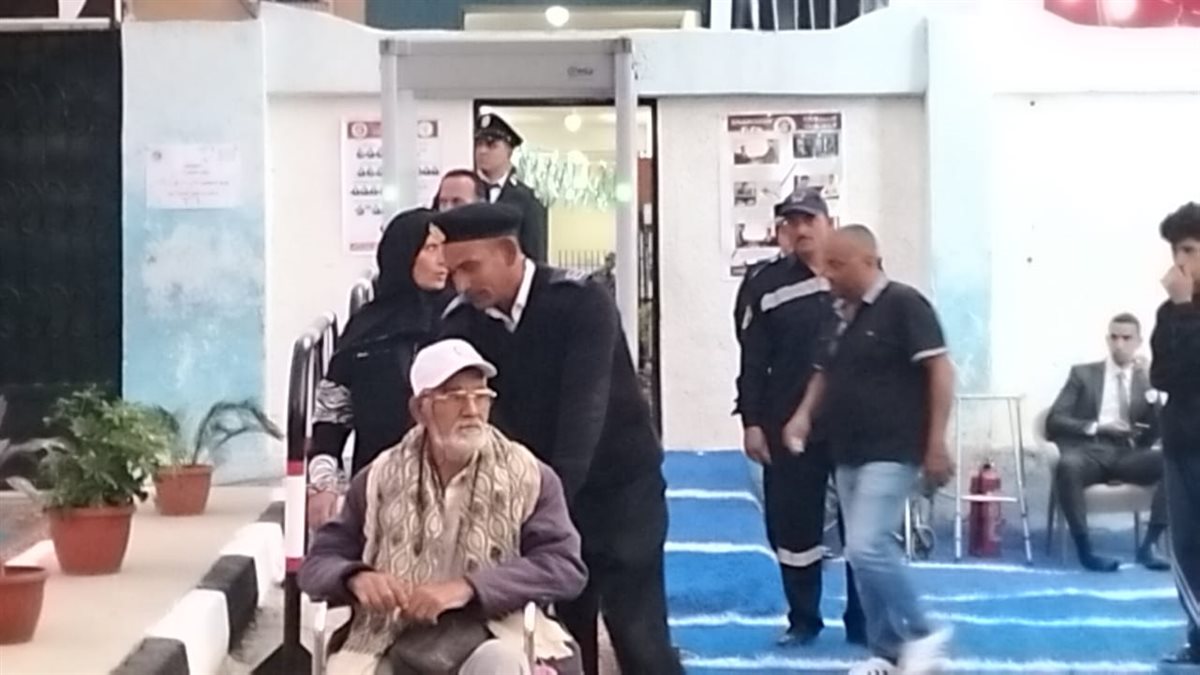 رجال أمن الإسماعيلية يعاونون ناخب في الوصول للجنته الانتخابية، فيتو