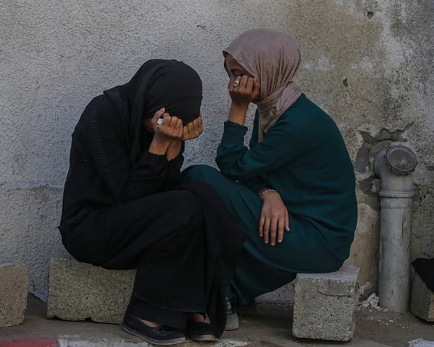 فلسطينيات خارج مستشفى الشفاء بعد استشهاد فراد من عائلتهن