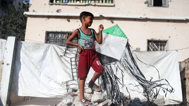 طفل فلسطيني يطلق طائرة ورقية في مخيم مؤقت للنازحين في مدينة غزة