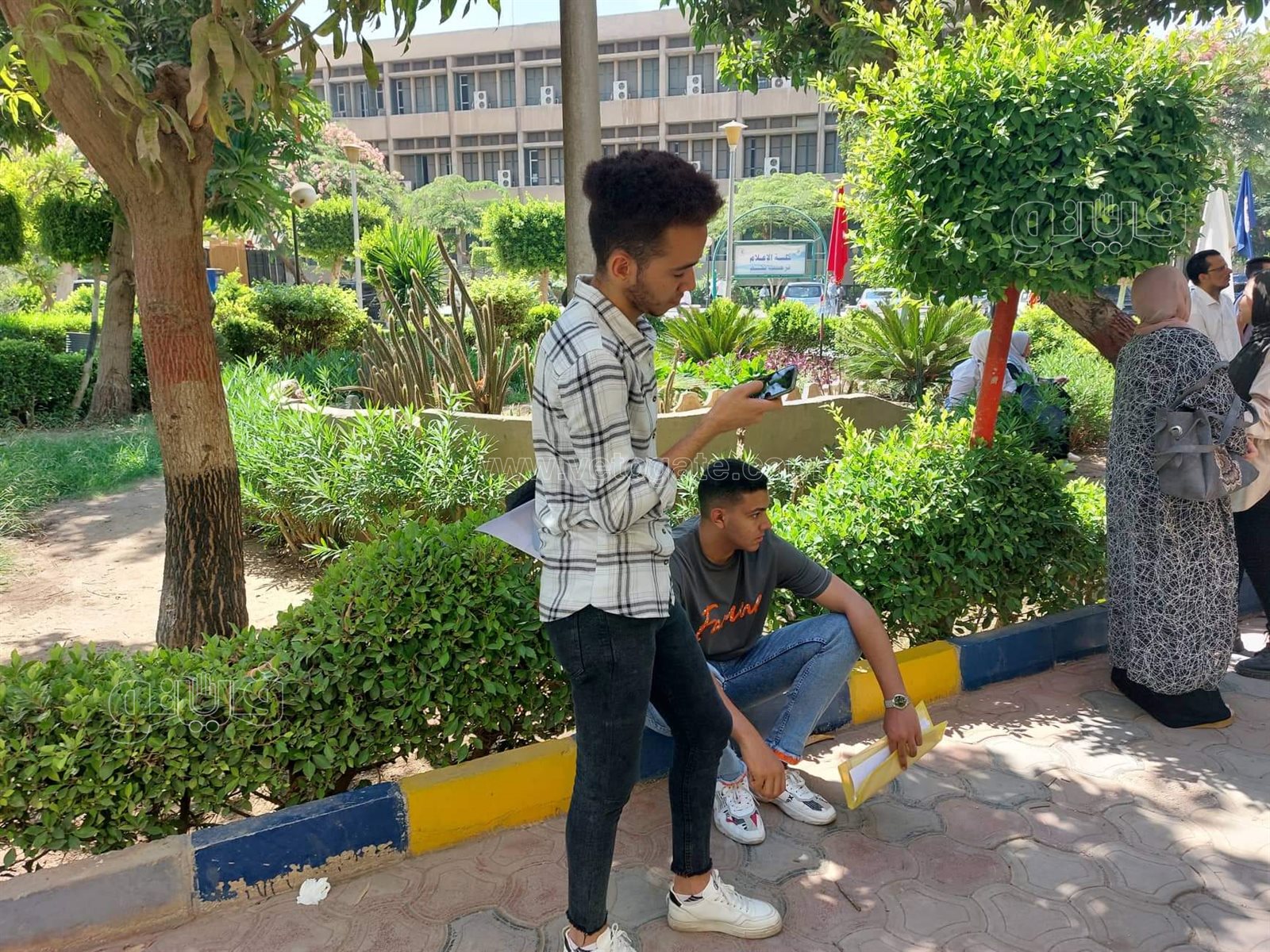 بالشمسية والملفات طلاب الثانوية يحتمون من الحر أمام كلية الإعلام (13)
