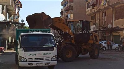 12 صورة ترصد إزالة مستودع لتخزين الحديد والصاج متعديا على أملاك الدولة في بورسعيد