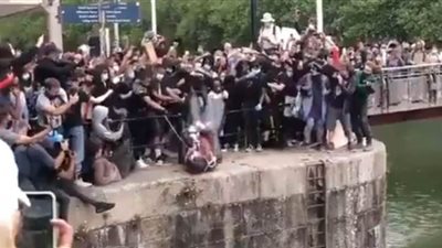 بريطانيا.. محتجون ضد العنصرية يرمون تمثالا لتاجر عبيد في النهر | فيديو