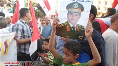 أطفال يرفعون صور السيسي أمام لجان الاستفتاء بمصر القديمة