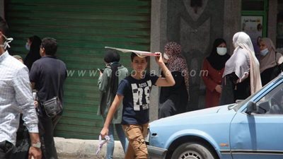 بالكاب والأوراق.. وسائل المواطنين للاحتماء من حرارة الشمس في أول أيام الصيف | صور