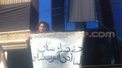 سيدة ترفع لافتة «أمي اتعرت» على سلم الصحفيين