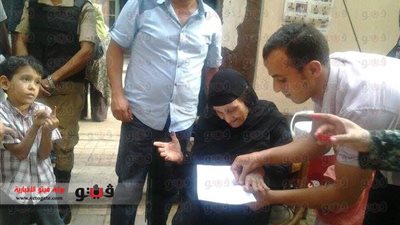 بالصور.. قاض يخرج لسيدة مسنة على باب اللجنة ليساعدها على الانتخاب