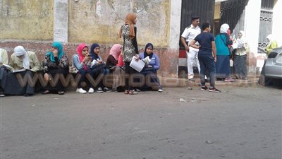 طالبات الثانوية العامة تحتمين من الشمس تحت الأشجار