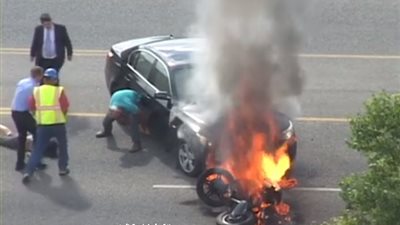 بالفيديو.. لحظة إنقاذ قائد دراجة نارية وإخراجه من أسفل سيارة تشتعل