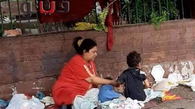 فريق التدخل السريع ينقذ سيدة تفترش كوبري أكتوبر | صور