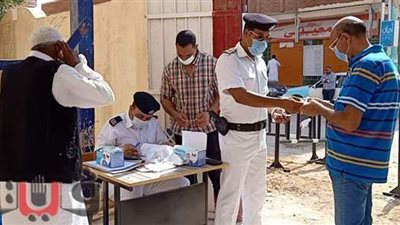 الشرطة توزع الكمامات على المواطنين بلجان انتخابات الشيوخ في مطروح | صور
