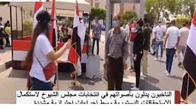 مواطنة تستقبل الناخبين بـ