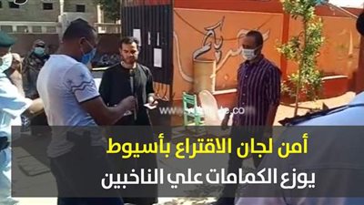 أمن لجان الاقتراع بأسيوط يوزع الكمامات علي الناخبين| فيديو