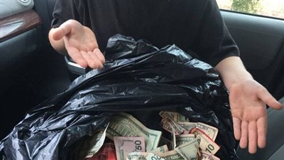 بالصور.. طفل يعثر على نقود مسروقة من بنك بالصدفة