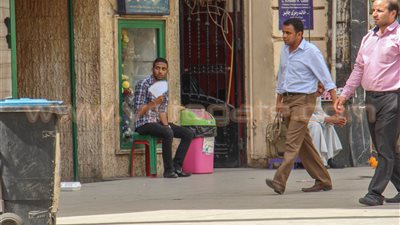 بالصور.. «الكابات» والجلوس تحت الأشجار وسائل الباعة للاحتماء من أشعة الشمس