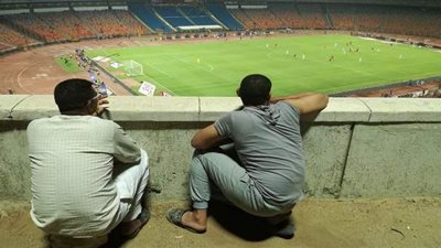 شغف المستديرة ولعنة كورونا تجبر عمال إستاد القاهرة على متابعة لقاء القمة خلف الأسوار