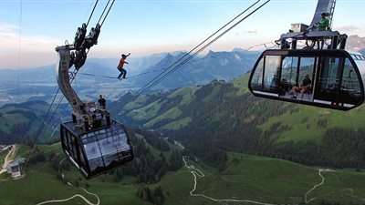 بالصور.. متهور يسير على أسلاك التلفريك بسويسرا