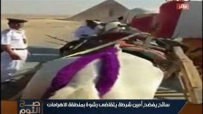 بالفيديو.. أمين شرطة يتقاضى رشوة من سائح أمريكي بالأهرامات