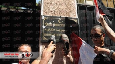 بالصور.. المتظاهرون يضعون الأحذية على لافتة السفارة التركية