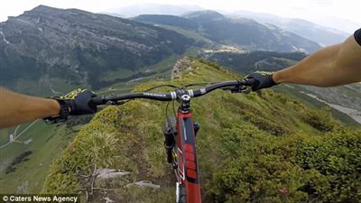 متهور يقود دراجته على حافة جبال الألب (فيديو وصور)
