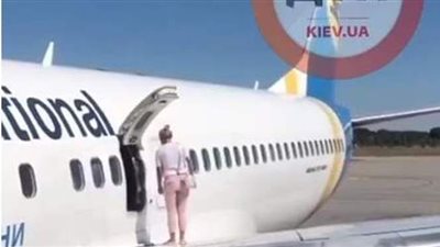 راكبة تفتح باب الطوارئ للتنزه على جناح طائرة | فيديو