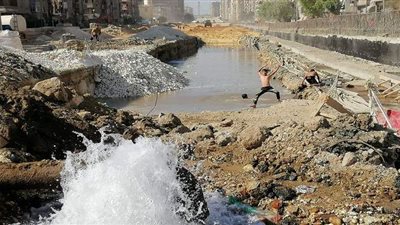 أطفال يسبحون في بركة مياه تكونت من كسر ماسورة بالعمرانية | فيديو وصور