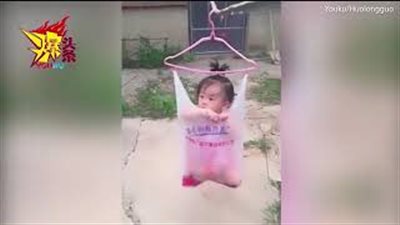 بالفيديو والصور.. انتقادات لأم علقت طفلتها بكيس بلاستيك على حبل غسيل