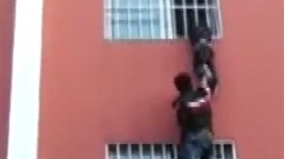 بالفيديو والصور.. لحظة إنقاذ طفل علقت رقبته بين قضبان نافذة بالطابق الثاني