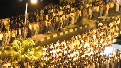 قاضي القضاة يوزع الحلوى على الناس بعد التراويح