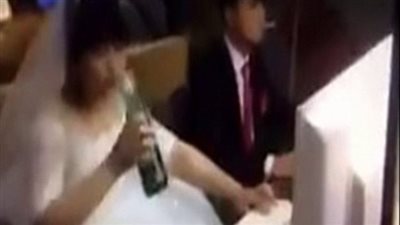 بالفيديو والصور.. عروسان يلعبان «الفيديو جيم» بملابس الزفاف