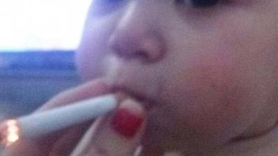 بالصور.. طفل يدخن ووالدته تمسك له السيجارة