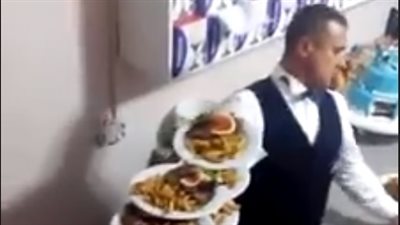 «جرسون» يحمل عددا غير متوقع من الأطباق على ذراعه (فيديو)