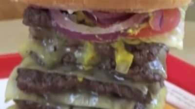 فتاة حسناء تخوض تحدي تناول ساندوتش برجر من تسع طبقات (فيديو)