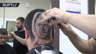 حلاق صربي يرسم كريستيانو رونالدو على شعر زبون (فيديو)