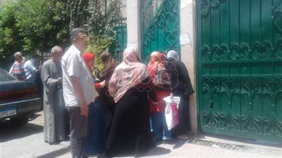 أولياء أمور يراجعون امتحان «الفرنساوي» من خلف سور مدرسة بالجيزة (صور)