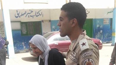 رجال القوات المسلحة يساعدون كبار السن على الوصول للجان (صور)