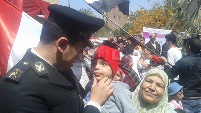 ضابط يداعب طفلًا أمام مدرسة التوفيقية بروض الفرج (صور)