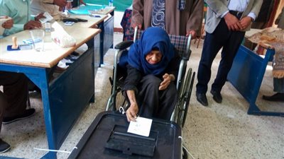 مسنة تدلي بصوتها في الانتخابات على كرسى متحرك بأسيوط