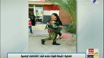 ضابط يحمل عجوزا أثناء إدلائها بصوتها (فيديو)