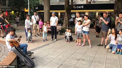 صبي يدهش المارة بعزفه (فيديو وصور)
