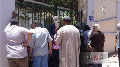 بالصور.. أولياء الأمور بأسوان يطمئنون على أبنائهم من خلف أبواب المدارس