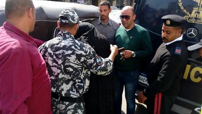 رجال الشرطة يساعدون عجوزا بعد الإدلاء بصوتها في روض الفرج (صور)