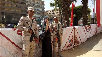 ناخبات يلتقطن صورًا مع رجال الجيش والشرطة بمصر الجديدة