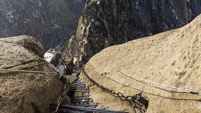 بالفيديو والصور.. سياح يخاطرون بحياتهم بهبوط من أعلى جبل صينى