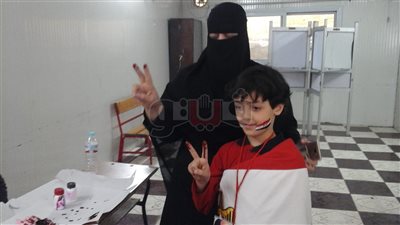 منتقبة تصطحب نجلها مرتديا علم مصر: «لازم يبقي راجل زي ابوه» (صور)