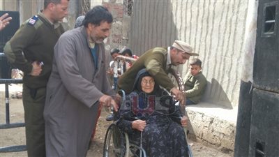 رجال الجيش يساعدون الناخبين بـ«الكراسي المتحركة» في بني سويف (صور)
