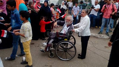 مسنة تساند زوجها للوصول إلى لجنته الانتخابية (صور)